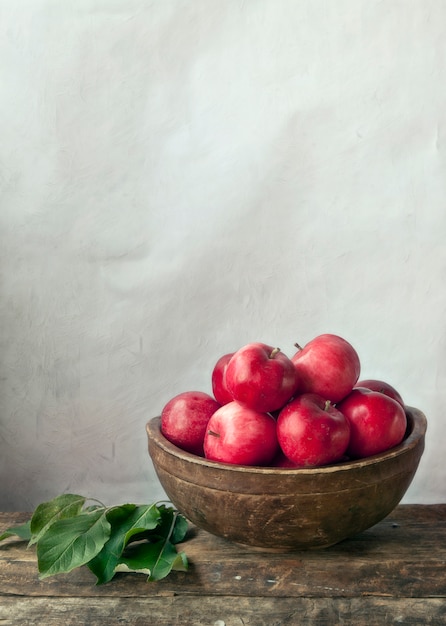 Chiuda in su delle mele rosse sulla tabella di legno bianca