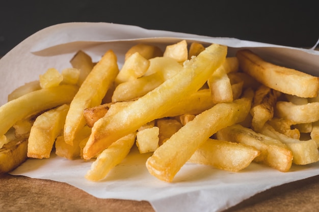 Chiuda in su delle patate fritte sulla tabella di legno.