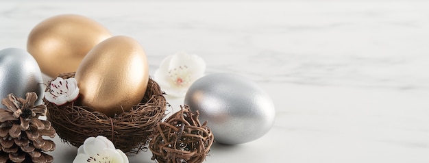 Chiuda in su delle uova di Pasqua d'oro e d'argento nel nido con il fiore di prugna bianco sul fondo della tavola in legno bianco brillante