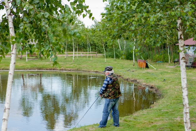 Chiuda in su di pesca del pescatore su un lago