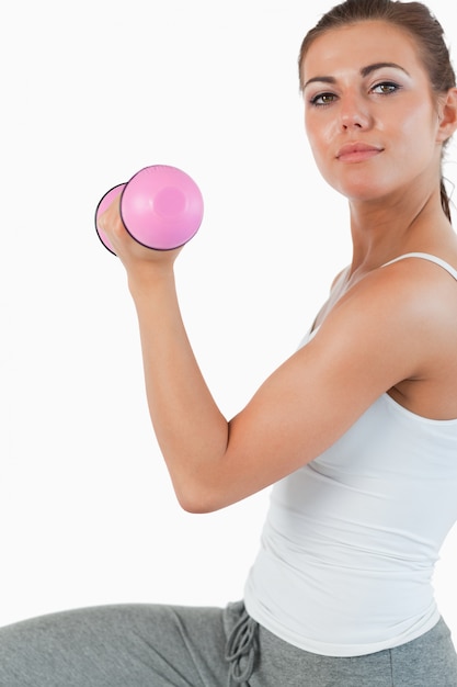 Chiuda in su di una donna che risolve con i dumbbells