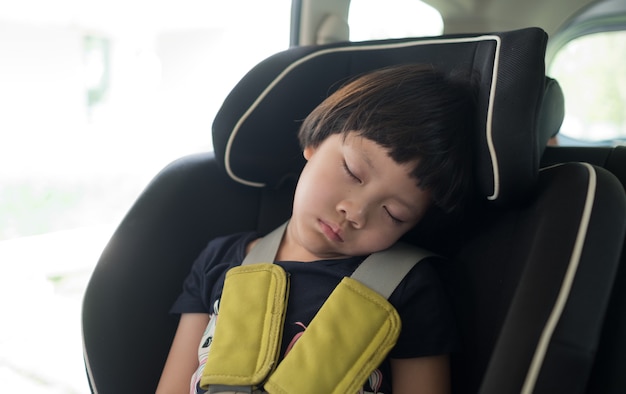 Chiuda in su sul bambino che dorme nella sede di automobile