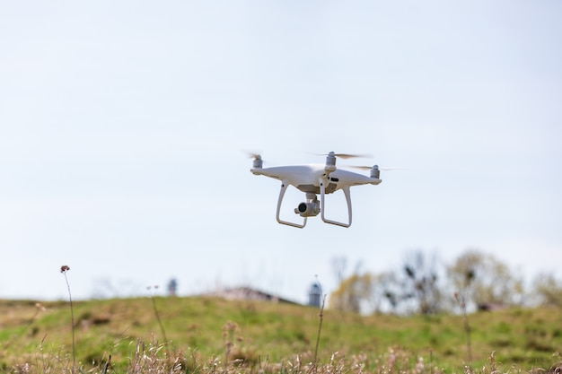 Chiuda in su sulla macchina fotografica bianca del fuco. Drone quadcopter in volo