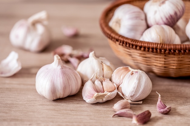 Chiuda in su un gruppo di aglio sulla tabella di legno della cucina