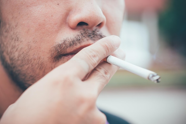 Chiuda in su uomo bello asiatico che fuma