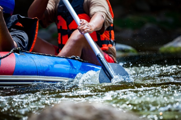 Chiuda su del rafting del giovane in un fiume.