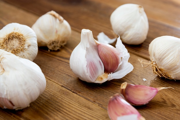 Chiuda su intero aglio sulla tavola di legno.