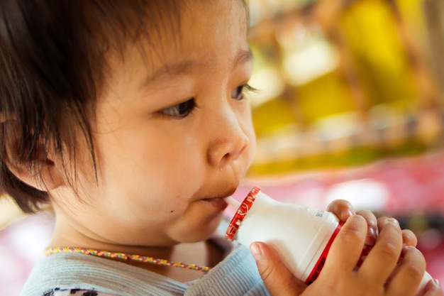 Chiuda sul bambino che beve latte pastorizzato