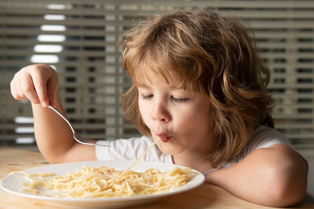 Chiuda sul colpo alla testa del bambino che mangia pasta, spaghetti. Fronte dei bambini, ritratto del ragazzino.