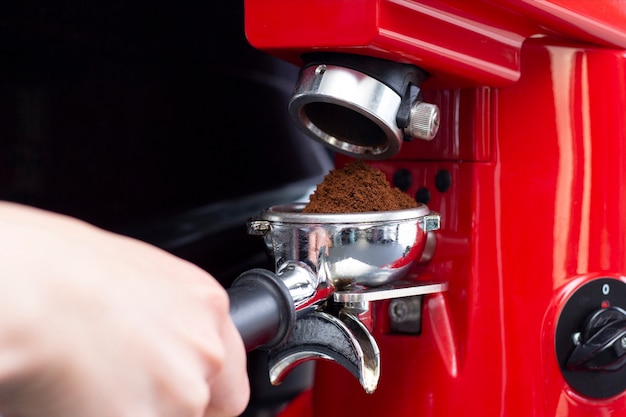 Chiuda sul colpo del barista professionista che prepara caffè espresso nell'esclusivo bar caffetteria o caffetteria