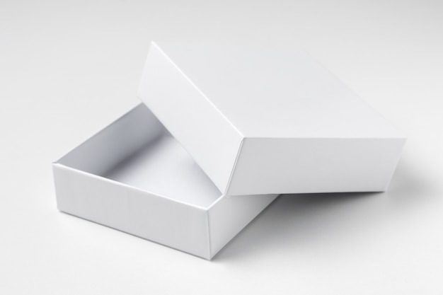 Chiuda sul contenitore di regalo aperto bianco del cartone