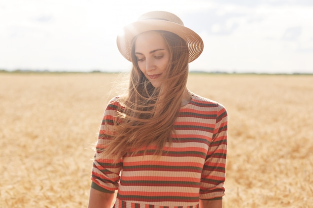 Chiuda sul ritratto all'aperto di bella donna in cappello di paglia