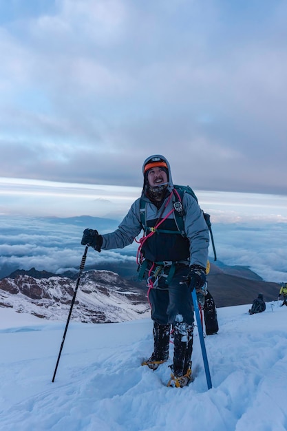 Chiuda sul ritratto dell'escursionista sul campo di neve e sullo sfondo della montagna