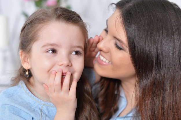 Chiuda sul ritratto della bambina con la madre che abbraccia