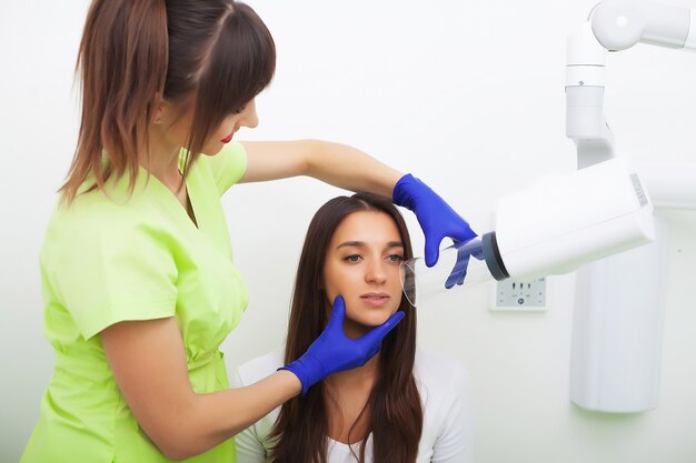 Chiuda sul ritratto della donna attraente che si siede nell'ufficio del dentista