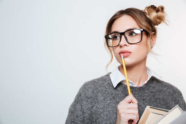 Chiuda sul ritratto della donna con i libri e la matita