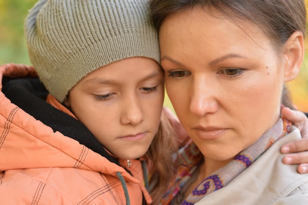 Chiuda sul ritratto della madre che abbraccia la figlia all'aperto