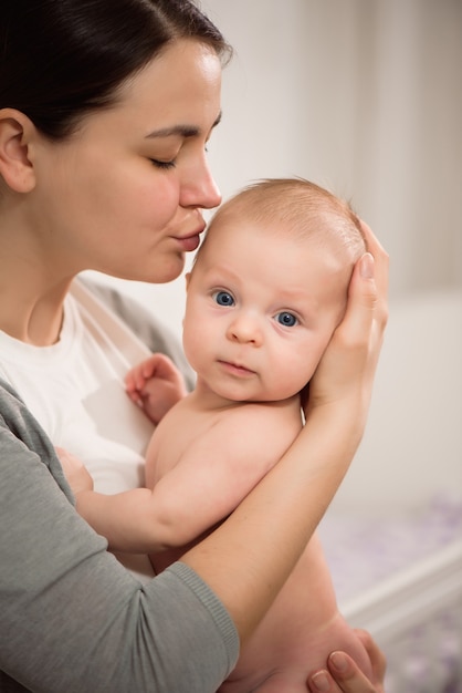 Chiuda sul ritratto della madre e del suo neonato. Sanità e amore medico concetto di festa della mamma di stile di vita della donna.