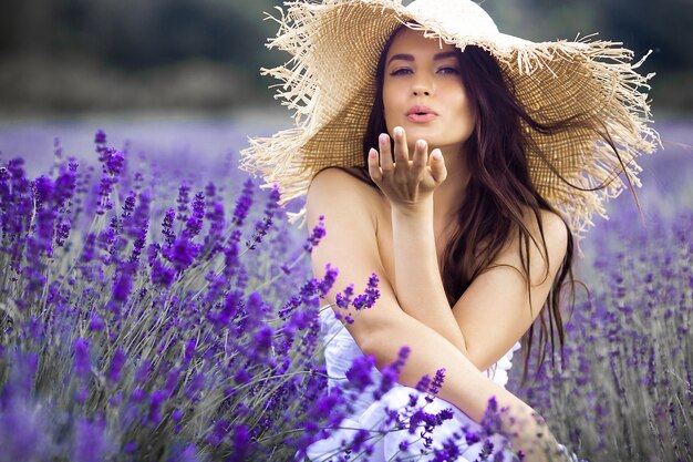 Chiuda sul ritratto di bella giovane donna nel giacimento della lavanda.