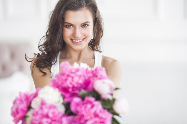 Chiuda sul ritratto di giovane bella donna con i fiori