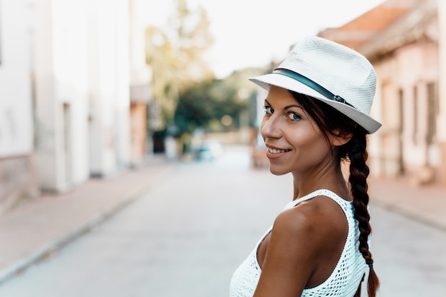 Chiuda sul ritratto di una donna sorridente con il cappello fuori