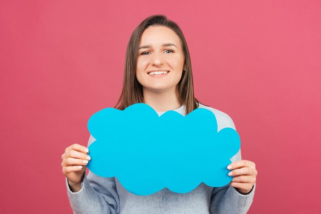 Chiuda sul ritratto di una giovane donna sorridente che tiene una nuvola di carta blu