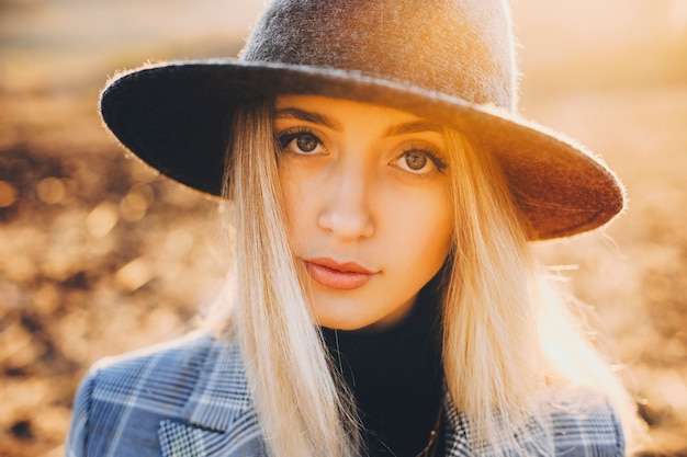 Chiuda sul ritratto di una ragazza caucasica bionda incredibile che esamina la macchina fotografica contro l'alba mentre esplora nuovi posti nel periodo delle vacanze di primavera.