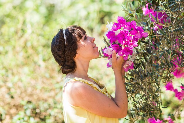 Chiuda sul ritratto romantico di bella donna elegante negli alberi del fiore