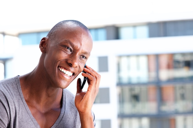 Chiuda sull&#39;afroamericano che ride con il telefono cellulare