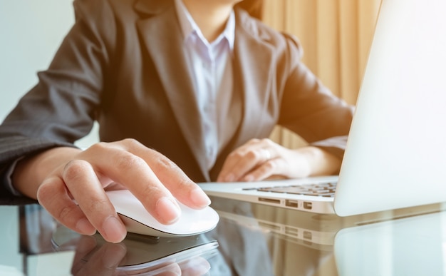 Chiuda sull&#39;ingegnere della donna della mano che lavora al suo computer portatile al cantiere