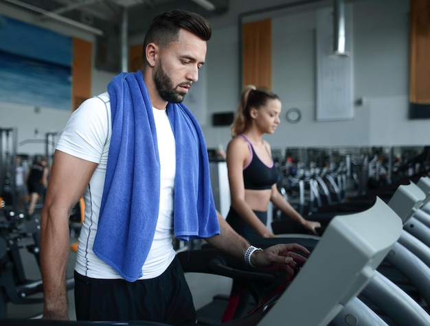 Chiuda sull'uomo attraente che corre su uno stile di vita sano di tapis roulant