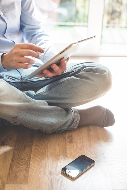 Chiuda sull'uomo di multitasking delle mani che per mezzo del ridurre in pani