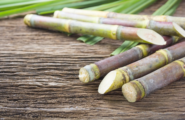 Chiuda sulla canna da zucchero su fondo di legno