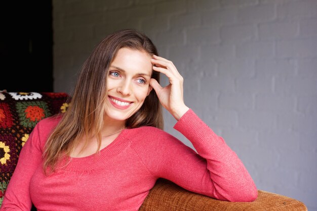 Chiuda sulla donna che sorride a casa