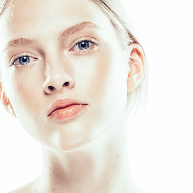 Chiuda sulla donna del fronte con la pelle di bellezza e capelli biondi beautful isolati su bianco. Colpo dello studio.