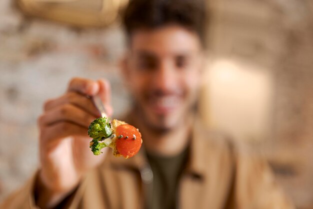 Chiuda sulla forcella della holding dell'uomo con il cibo