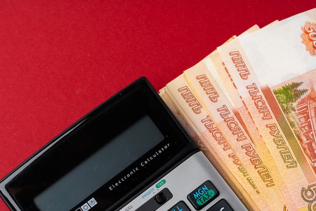 Chiuda sulla foto della pila di rubli russe dei soldi con il calcolatore