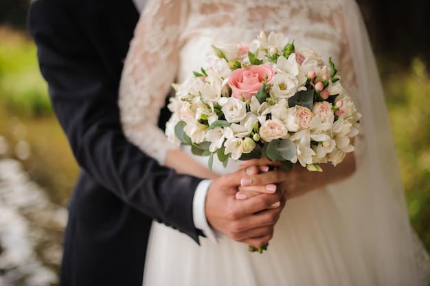 Chiuda sulla foto di uno sposo che abbraccia una sposa