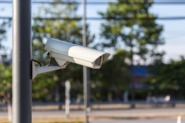 Chiuda sulla macchina fotografica del CCTV di sicurezza che funziona sulla strada e vaga dell&#39;automobile