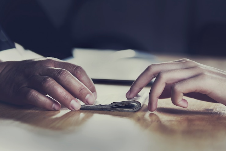 Foto chiuda sulla mano che dà i soldi per il partner sullo scrittorio