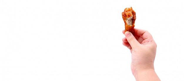 Chiuda sulla mano che giudica le ali di pollo fritto coreane isolate su un fondo bianco in studio