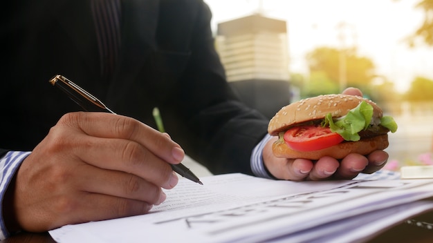 Chiuda sulla mano di funzionamento dell&#39;ufficiale e tenga l&#39;hamburger e la penna fuori dell&#39;ufficio.