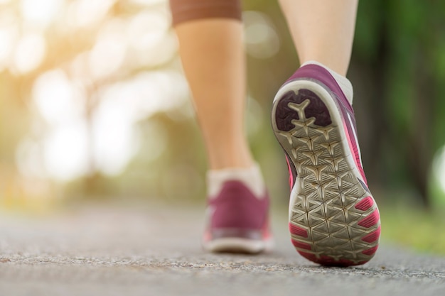 Chiuda sulla scarpa della donna che corre sulla strada, pareggiando da solo al parco, sport stile di vita sano