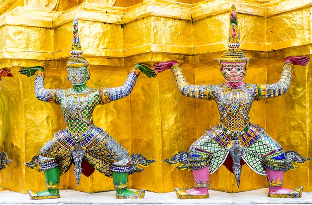 Chiuda sulla statua gigante tailandese alla pagoda dorata al grande palazzo, il tempio di Emerald Buddha (Kaew di pra di Wat) a Bangkok, Tailandia.