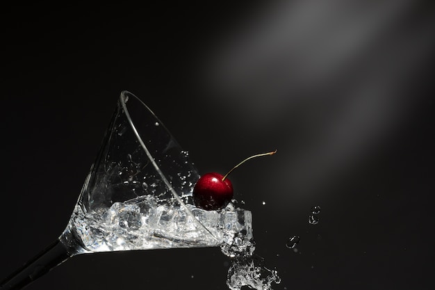 Chiuda sulla vista di spruzzata dell&#39;acqua con la ciliegia di caduta.