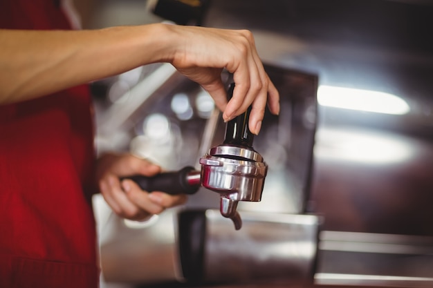 Chiuda sulla vista di un caffè che preme il caffè