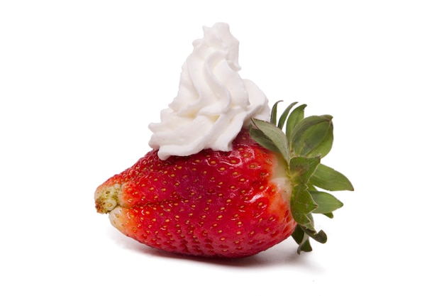 Chiuda sulla vista di una fragola fresca con crema isolata su una priorità bassa bianca.