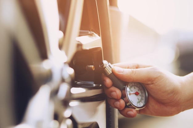 Chiudere fino a mano uomo parcheggio auto un controllo e gonfiare il pneumatico riempire l'aria per una guida sicura in movimento Trasporto viaggio concetto di veicolo