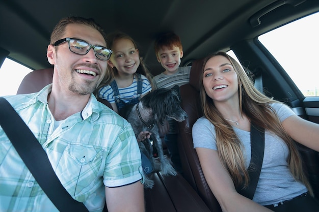 Chiudere la famiglia felice in un confortevole concetto di vacanza in famiglia in auto