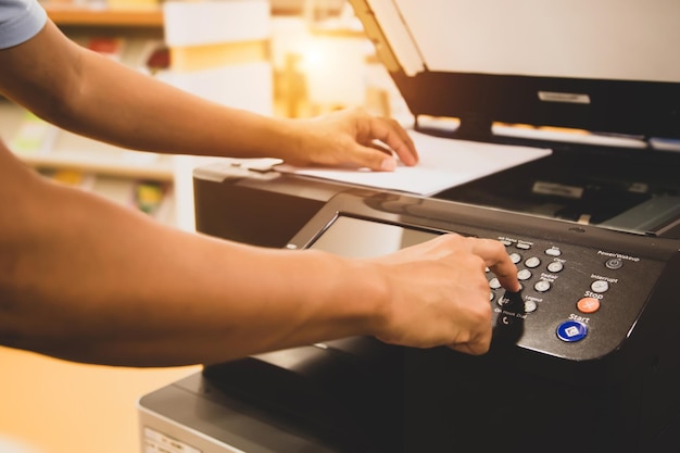 Chiudere la mano dell'uomo dell'ufficio premere il pulsante sulla fotocopiatrice.